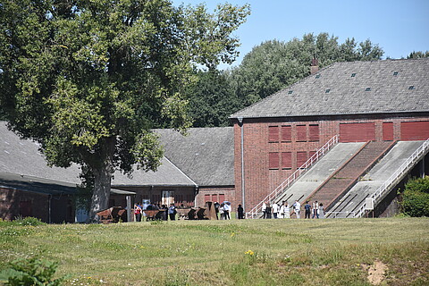 Besucher der Gedenkstätte vor dem historischen Klinkerwerk