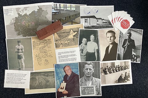 Fotos (meist schwarzweiß) und Gegenstände liegen ausgebreitet.