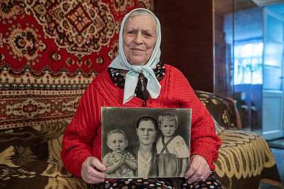 Pelаheya Novikova hält ein schwarzweiß Foto ihrer Familie