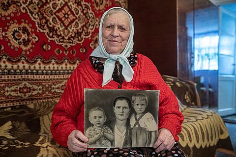 Pelаheya Novikova hält ein schwarzweiß Foto ihrer Familie