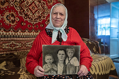 Pelаheya Novikova hält ein schwarzweiß Foto ihrer Familie
