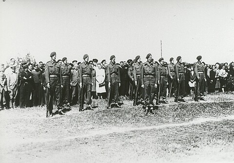 Schwarz-Weiß-Foto von Soldaten, die in Reihe und Glied stehen.
