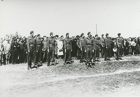 Schwarz-Weiß-Foto von Soldaten, die in Reihe und Glied stehen.