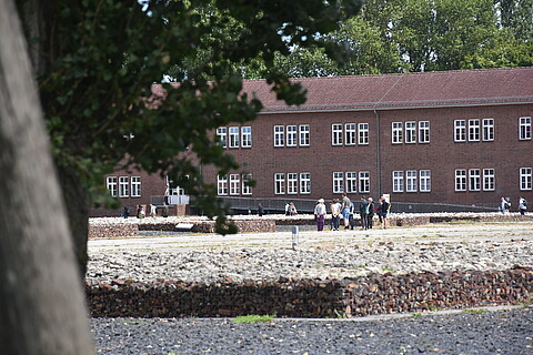 Eine kleine Besuchergruppe steht auf dem Gelände der KZ-Gedenkstätte Neuengamme