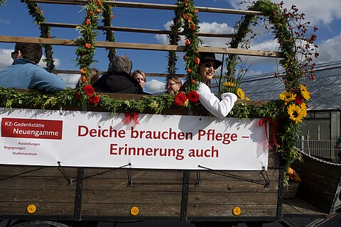 Erntedankwagen der Gedenkstätte mit Banner "Deiche brauchen Pflege - Erinnerung auch"