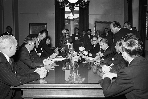 Unterzeichnung des Luxemburger Abkommens 10.9.1952. Ein Dutzend Männer sitzt an einem Tisch. Schwarzweiß Foto