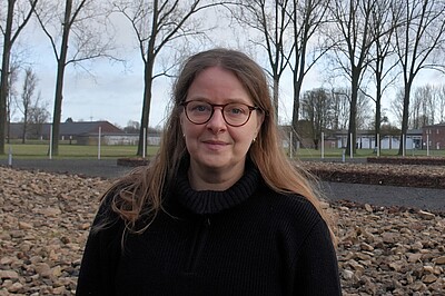 Susann Lewerenz hat lange Haare und trägt eine Brille. Im Hintergrund Bäume.