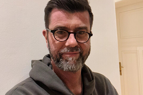 Portrait von Jaromir Balzar. Er trägt eine Brille und einen Kapuzenpullover.