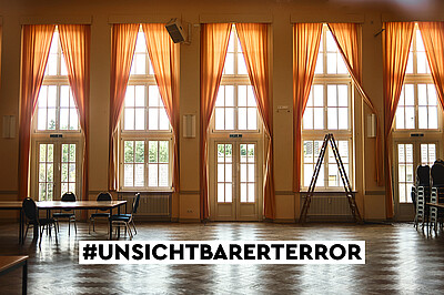 Foto eines Saales mit organgen Gardinen mit Titel "Unsichtbarer Terror"