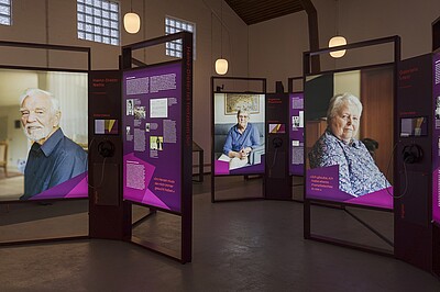 Blick in die Ausstellung "trotzdem da!" mit großformatigen Portraits von Frauen und Männern.