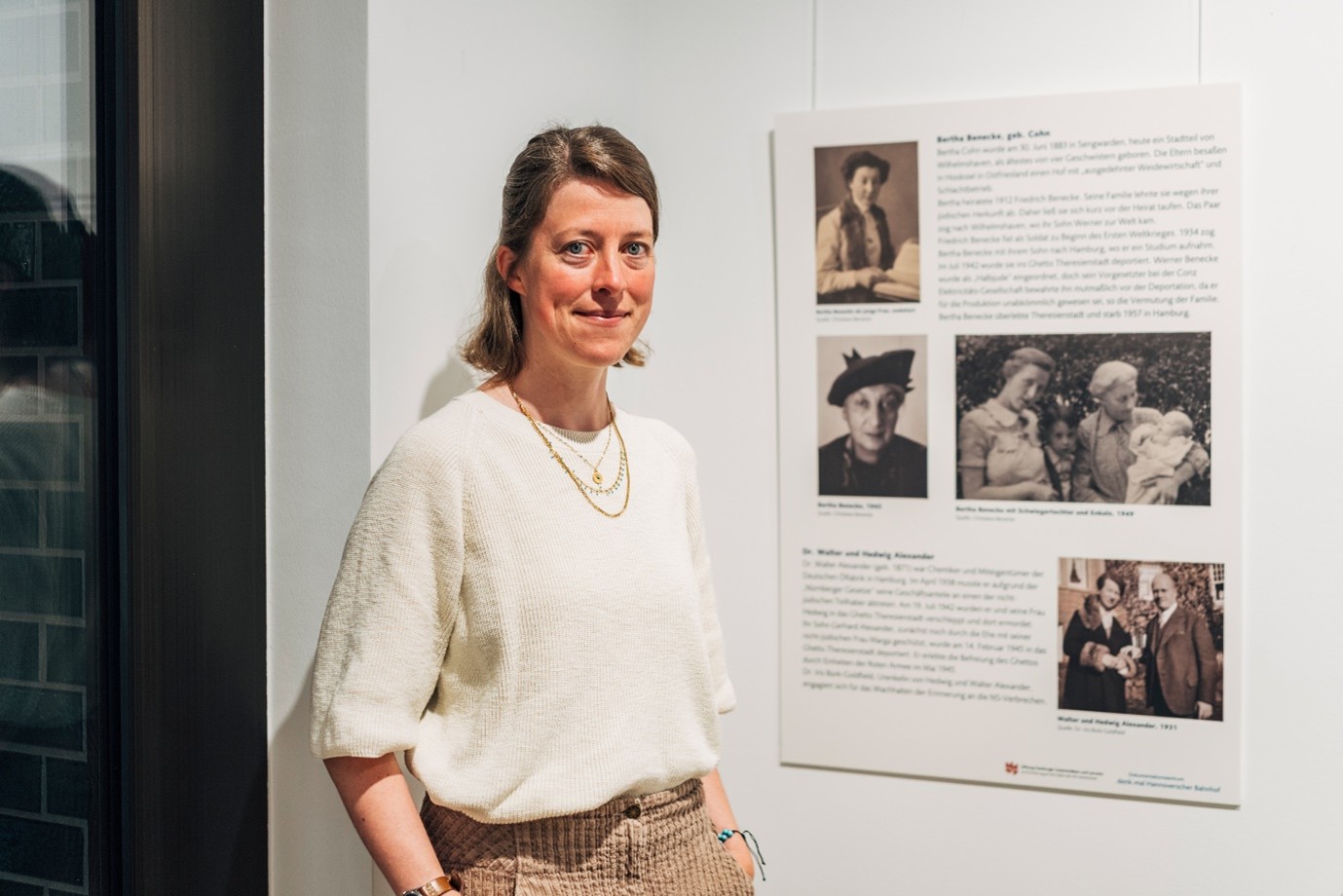 Christiane Becke mit der Ausstellungstafel über ihre Urgroßmutter Bertha Benecke